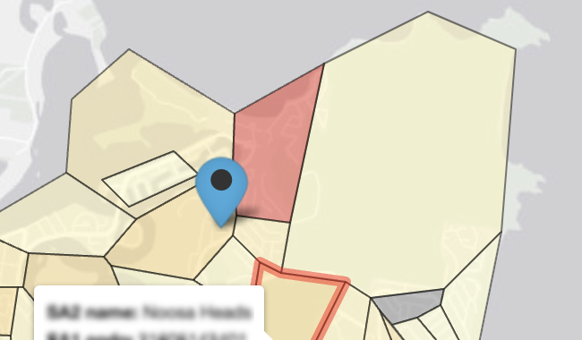 In the background, a very light grey map of Peregian Springs in Queensland, with the ocean in a darker grey.
              In the foreground on land, there are shapes with black borders in shades of yellow, orange and red, indicating Statistical Areas 1. A blue pin icon with a black dot inside indicates an evacuation area. 
              In the bottom left-to-center, a white caption box has some blurred, illegible text in it.